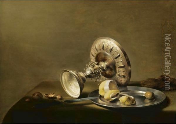 A Still Life With An Overturned Silver Tazza, A Silver Plate With A Partly Peeled Lemon And An Olive, With Walnuts And Hazelnuts Oil Painting - Pieter Claesz.